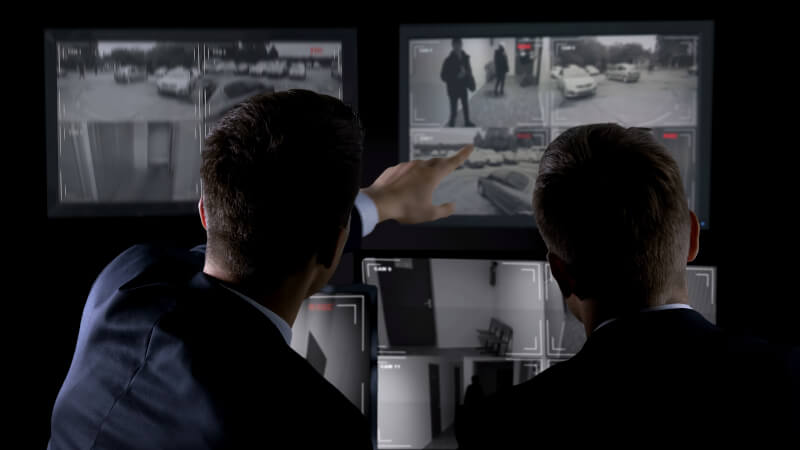 Private agents monitoring CCTV footage, searching for criminal, discussion Personal Investigator in Charlotte, North Carolina